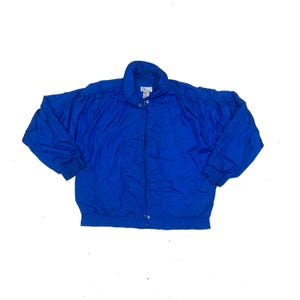 May include: A bright blue zip-up jacket with a stand-up collar. The jacket has a smooth, shiny finish and a slightly puffy look.