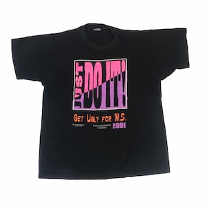 May include: Black t-shirt with a pink and purple "Just Do It!" graphic. The text "Get Ugly for M.S." is below the graphic. The text "Ugly Bartender Contest 1991" is below the text.