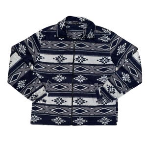May include: A navy blue fleece jacket with a full zip. The jacket displays a repeating pattern of white snowflakes, grey diamonds, and geometric shapes. It has a collared neckline and two side pockets.