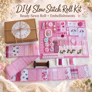 Peut inclure: Un kit de couture DIY Slow Stitch Roll comprenant une boîte en carton marron avec un napperon blanc, un tapis en tissu rose avec divers ornements, boutons, dentelles et patchs floraux, un long rouleau de tissu patchwork rose et deux bobines.