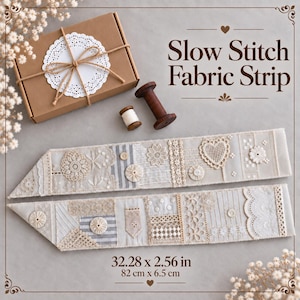 May include: Two long fabric strips featuring cream and beige lace, embroidery, and small buttons, accompanied by a brown cardboard box tied with twine, a white paper doily, and two wooden spools. The text reads Slow Stitch Fabric Strip 32.28 x 2.56 in.