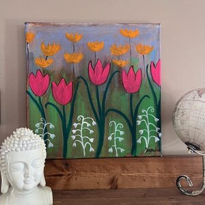 May include: A painting of a field of pink and yellow flowers. The flowers are painted in a stylized, whimsical style. The background is a light blue color. The painting is signed "Jamie".