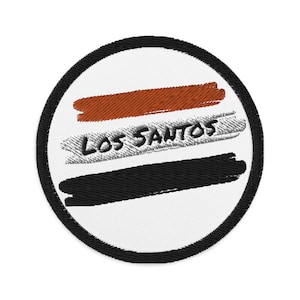 Op de afbeelding: Een witte ronde patch met een zwarte rand. De patch heeft drie horizontale strepen in bruin, grijs en zwart. De grijze streep heeft de tekst "LOS SANTOS" in zwart.