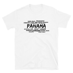 Può includere: T-shirt bianca con la parola "PANAMA" in grandi lettere nere stilizzate. La maglietta presenta anche i nomi delle province e delle regioni panamensi in un carattere più piccolo, nero, tra cui Guna Yala, Colón e Chiriquí.