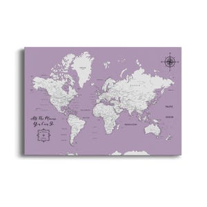 May include: A rectangular world map print featuring light gray continents against a solid lavender background. The text All The Places You Can Go is printed in black on the left side, accompanied by a decorative compass rose icon.