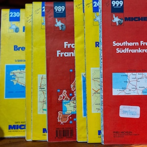May include: A collection of vertical Michelin road maps featuring yellow and red covers with blue identification boxes. The maps display regional names like Southern France, Sudfrankreich, and France, along with the Michelin logo and numbers.