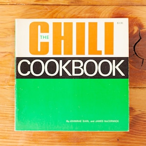 May include: The Chili Cookbook, a vintage paperback with a green cover and orange and black text. The title reads "The Chili Cookbook" with the word "Chili" in large orange letters.