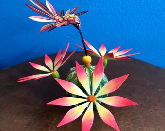 メキシコ、オアハカ産のハチドリの木彫りが施されたアレブリヘの花咲く 