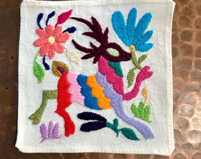Otomi hand embroidered muslin coaster with multicolored spirit animal and flowers.