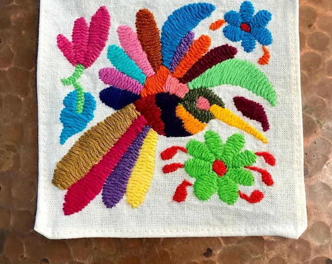 Otomi hand embroidered muslin coaster with multicolored bird and flowers.
