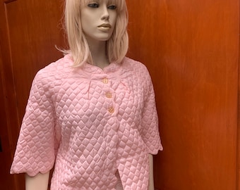 May include: A pink quilted robe with a scalloped hem and gold buttons.