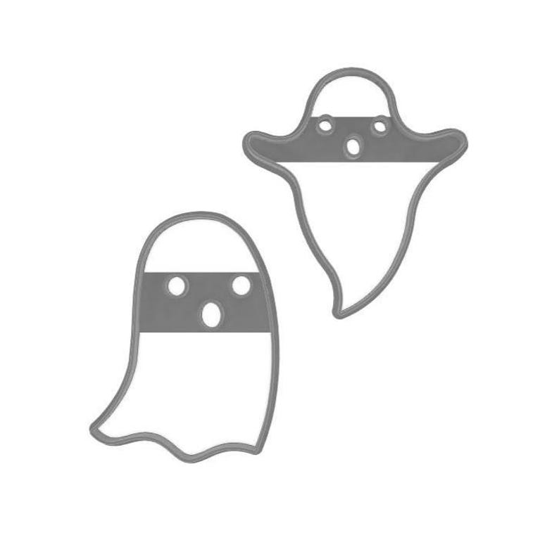 May include: Two gray ghost-shaped cookie cutters. Each cutter has a horizontal band with three circular cutouts for eyes and mouth. The ghost shapes are outlined in gray, with a white interior.