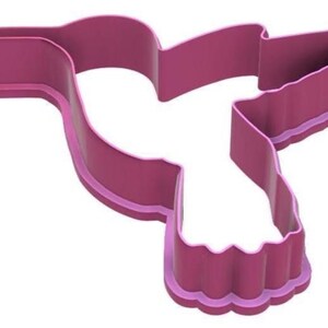 Puede incluir: Cortador de galletas con forma de colibr&iacute; de color magenta. El cortador de pl&aacute;stico presenta un contorno detallado de un colibr&iacute; en vuelo. Los bordes son lisos y el dise&ntilde;o es adecuado para hornear.