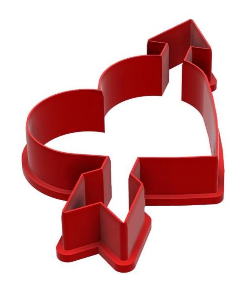 May include: A red plastic cookie cutter in the shape of a heart pierced by an arrow. The cutter has a thick, rounded edge and a simple, clean design, perfect for Valentine's Day or other romantic occasions.