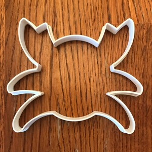Peut inclure: Un emporte-pièce en plastique blanc en forme de crabe. Le découpoir a un contour détaillé d'un crabe avec des pinces et un corps segmenté. Le découpoir est conçu pour la pâtisserie et l'artisanat.