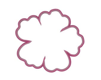 May include: A pink flower-shaped cookie cutter with a scalloped edge. The cutter is made of a solid, opaque material and is set against a white background. The design is simple and elegant.