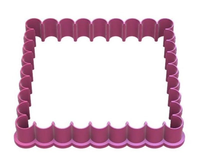 Puede incluir: Un cortador de galletas rectangular magenta con borde festoneado. El dise&ntilde;o del cortador presenta una serie de arcos redondeados a lo largo de su per&iacute;metro, creando un borde decorativo. El interior est&aacute; abierto, listo para dar forma a la masa.