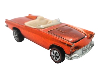 May include: Orange die-cast toy car model of a 1950s Ford Thunderbird convertible. The car has a white interior and black wheels.