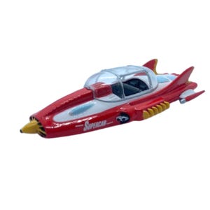 May include: A red and white toy Supercar with a clear bubble top. The toy car has yellow accents and the word "Supercar" printed on the side. The car has a sleek, aerodynamic design.