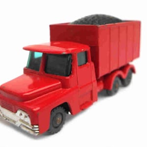 May include: A red toy dump truck with a black load in the bed. The truck has a detailed cab and four wheels.