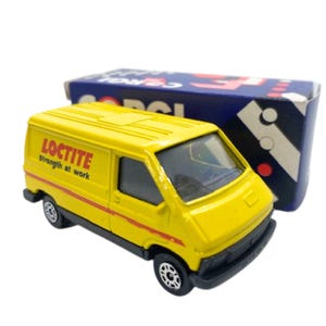 Puede incluir: Una furgoneta de juguete amarilla con el logotipo de Loctite y el texto "strength at work" en el lateral. La furgoneta tiene ruedas negras y rayas rojas. Una caja azul y blanca está en el fondo.