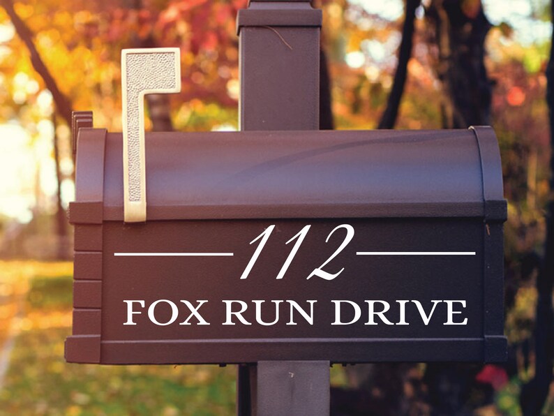 May include: A black mailbox with a white number "112" and the text "FOX RUN DRIVE" on the front. The mailbox has a gold-colored flag.