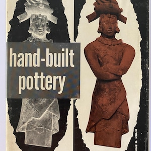 May include: Book cover featuring a terracotta-colored pottery figure with a headdress and necklace. The figure is set against a black and white background. The text "hand-built pottery" is displayed in a rectangular box across the image.