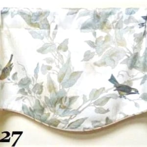 May include: A valance with a white background featuring a botanical design with birds and foliage in shades of green, blue, and brown. The valance has a scalloped bottom edge and the number "127" is printed on the bottom left.