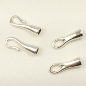 May include: Four silver jewelry clasps, two hook and eye clasps and two loop clasps.