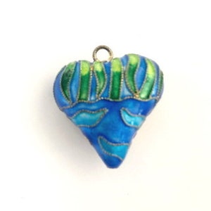 Op de afbeelding: Een blauwe en groene emaille hart hanger met een zilveren lus aan de bovenkant.