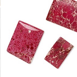 May include: Three red and white marbled stone rectangular pendants with holes for stringing.