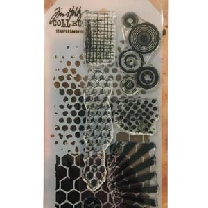 May include: A clear plastic stamp and stencil set with various patterns, including circles, hexagons, and a star. The package includes the text "Tim Holtz Collection" and "Stampers Anonymous". The set contains 8 pieces.