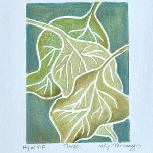 May include: A green and brown print of three overlapping leaves with white veins. The print is titled "Trees" and signed "W.J. Vernay". The number "14/100 V.E." is printed in the bottom left corner.