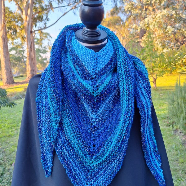 Triangle scarf knitted in blue and green DK wool and acrylic yarn with a touch of sparkle. Soft and snuggly. Wear it in a variety of ways!