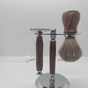 Puede incluir: Un juego de afeitado con una navaja de mango de madera, un cepillo de mango de madera y un soporte cromado.