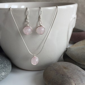 May include: A set of rose quartz earrings and a necklace with silver chain and rose quartz pendant.