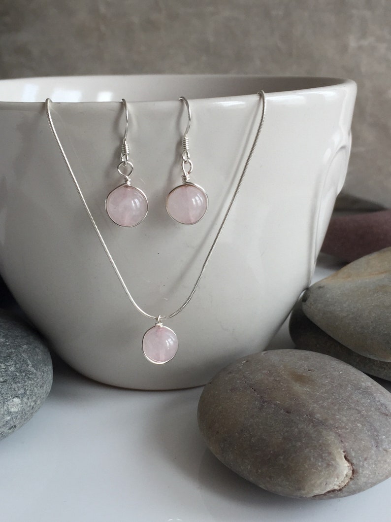 May include: A set of rose quartz earrings and a necklace with silver chain and rose quartz pendant.
