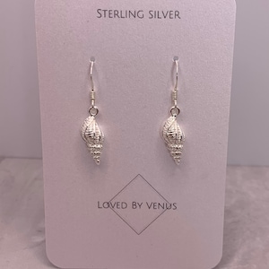May include: Sterling silver earrings featuring a seashell design. The earrings are on a white card with the text "Sterling Silver" and "Loved by Venus".