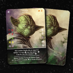 Puede incluir: Una carta coleccionable de Star Wars con Yoda, un Gran Maestro, con una cara verde y orejas grandes. La carta tiene un esquema de color morado y verde e incluye el texto: "YODA, Gran Maestro, 3, Después de que otra nave amiga a un rango de 0-3 gaste 1 o más, puedes gastar 1. Si lo haces, esa nave recupera 1. CONTROLES INTUITIVOS: Durante la fase del sistema, puedes realizar una acción morada o morada. Ferenc Pakse Art."