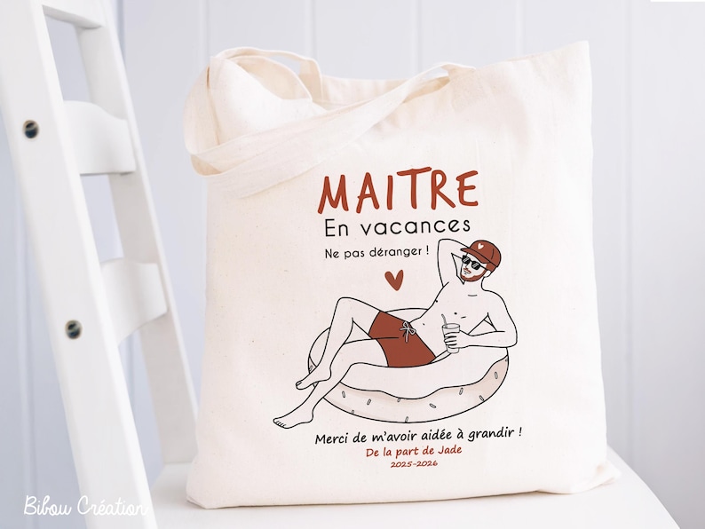May include: A cream-colored canvas tote bag featuring a graphic illustration of a person relaxing on an inflatable pool float. The text reads MAITRE En vacances Ne pas d&eacute;ranger ! Merci de m'avoir aid&eacute;e &agrave; grandir ! De la part de Jade 2025-2026.