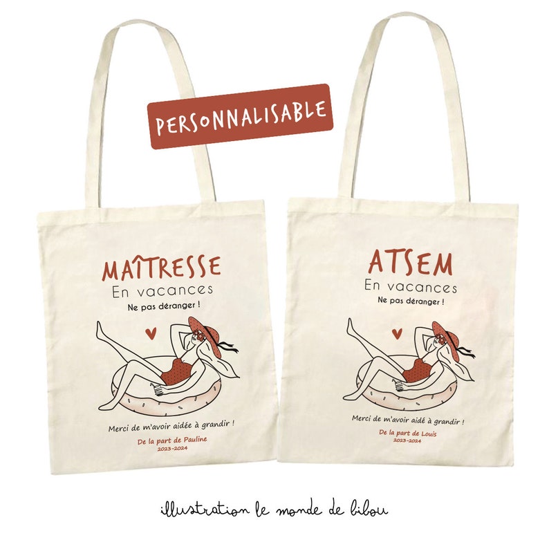 May include: Two off-white canvas tote bags featuring a graphic of a person in a red swimsuit and sun hat relaxing on an inflatable ring. Text includes "MA&Icirc;TRESSE En vacances Ne pas d&eacute;ranger !" and "ATSEM En vacances Ne pas d&eacute;ranger !" with custom names.