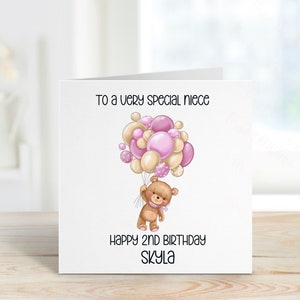 May include: A white card with a pink and beige teddy bear holding balloons that says "To a very special niece Happy 2nd Birthday Skyla"