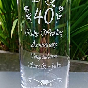 May include: A clear glass vase with a design etched into the side. The design includes two birds, a heart, flowers, and the number 40. The text "Ruby Wedding Anniversary" and "Congratulations Steve & Jackie" is also etched into the glass.