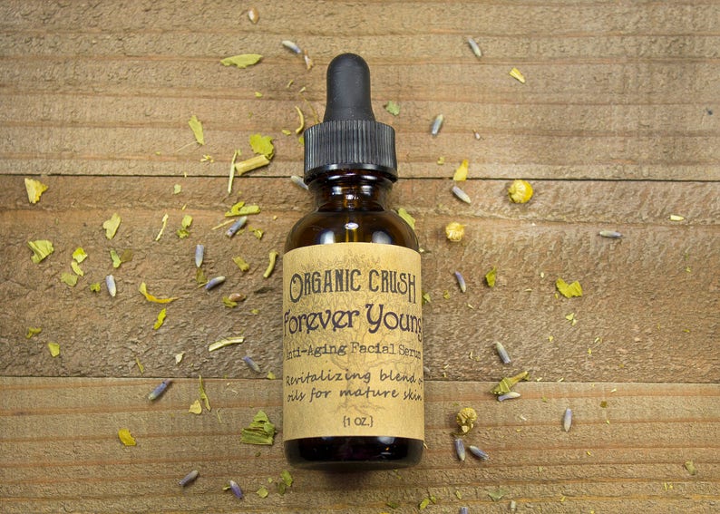 K&ouml;nnte beinhalten: Eine braune Glasflasche mit Tropfer und einem Etikett mit der Aufschrift "ORGANIC CRUSH Forever Youngs Anti-Aging Facial Serum Revitalizing blend, oily for mature skin (1 OZ.)"