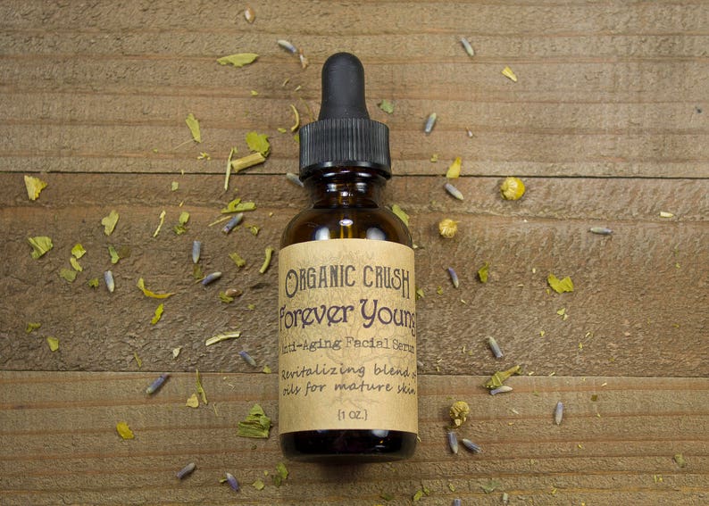 K&ouml;nnte beinhalten: Eine braune Glasflasche mit Tropfer und einem Etikett mit der Aufschrift "ORGANIC CRUSH Forever Young Anti-Aging Facial Serum Revitalizing blend oils for mature skin (1 oz.)"