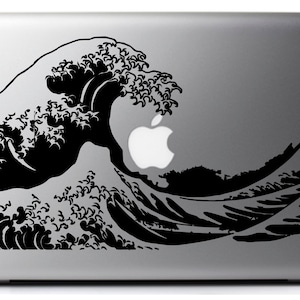Puede incluir: Una pegatina en blanco y negro de la Gran Ola de Kanagawa de Hokusai, una famosa estampa japonesa en madera, aplicada a un portátil plateado.
