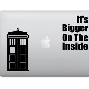 Pode incluir: Um adesivo de laptop preto e branco com a silhueta de uma caixa de polícia e o texto "It's Bigger On The Inside".