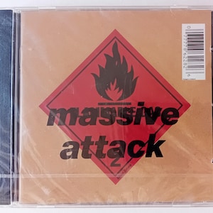May include: A red and black warning sign with a flame graphic and the text "massive attack" on a brown background.