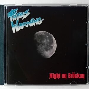 May include: A black CD case with a black and white image of a crescent moon against a starry night sky. The text "Fates Warning" is in blue and white lettering and the text "Night on Bröcken" is in red lettering.