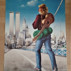 Puede incluir: Una persona con el pelo largo y rubio camina hacia atrás desde la cámara en un puente. La persona lleva una camisa roja, pantalones vaqueros azules y una mochila verde. Lleva una guitarra a la espalda. El puente está sobre una ciudad con edificios altos, incluidas las Torres Gemelas.